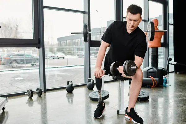 Un hombre determinado con una pierna protésica hace ejercicios con una barra en un gimnasio, esforzándose hacia la fuerza y el empoderamiento. - foto de stock