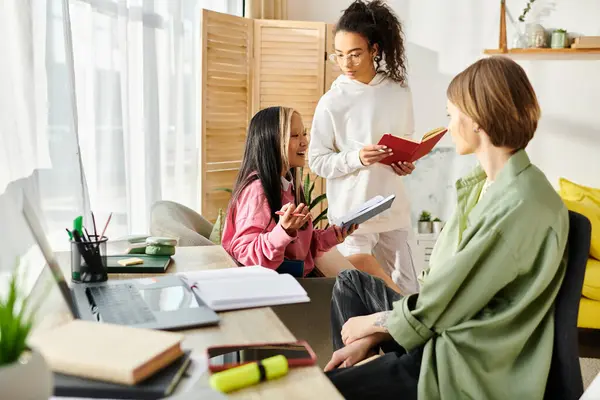 A diverse group of teenage girls of different ethnicities and backgrounds are gathered around a table, studying together from home. — Stock Photo