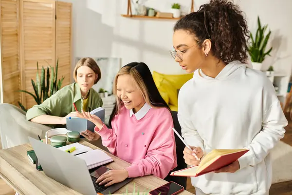 A group of interracial teenage girls engage in collaborative studying with laptops at a table, fostering friendship and education. — Stock Photo