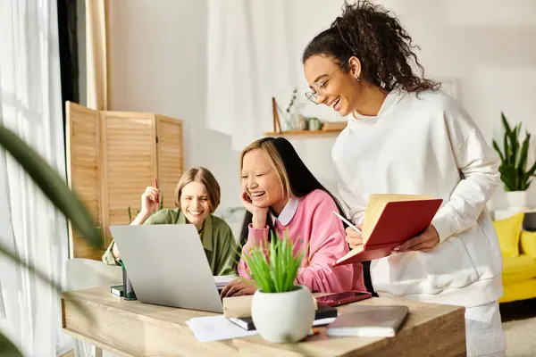 Multicultural young women collaborate on laptops at a table, focused on virtual education and cultivating friendship. — Stock Photo