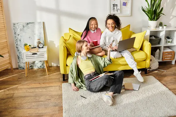 Un grupo de adolescentes interraciales estudian y socializan en un sofá amarillo brillante, fomentando la amistad y el crecimiento educativo. — Stock Photo