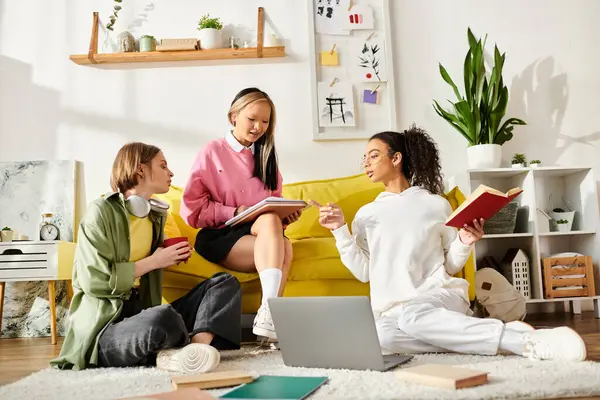A diverse group of teenage girls happily studying on a vibrant yellow couch, showcasing friendship and dedication to education. — Stock Photo
