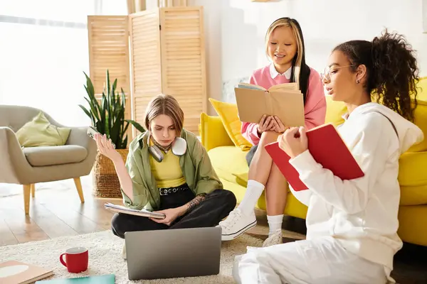 Un gruppo di ragazze adolescenti di diversa provenienza sedute intorno a un computer portatile, che studiano insieme da casa. — Foto stock