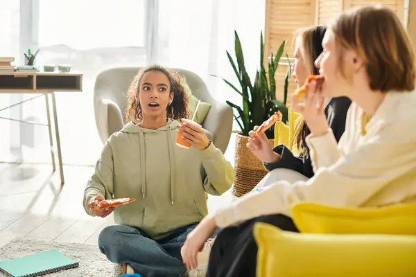 Diverse teenage girls gathered around a table, enjoying food and each others company in a heartwarming display of friendship. — Stock Photo