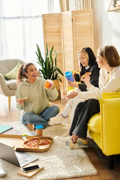 Un gruppo eterogeneo di donne, tra cui ragazze adolescenti interrazziale, seduti insieme in un soggiorno caldo e invitante, godendosi reciprocamente compagnia. — Foto stock