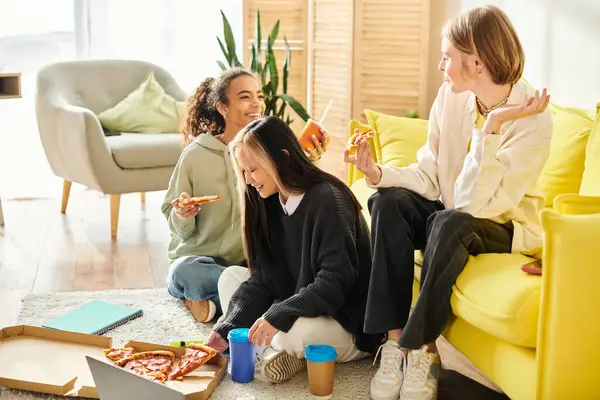 Diverso grupo de chicas adolescentes sentadas en el suelo, pegadas sobre rebanadas de deliciosa pizza. - foto de stock