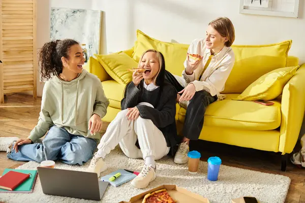 Un variegato gruppo di ragazze adolescenti si rilassano e legano su un divano giallo brillante in un ambiente accogliente. — Foto stock