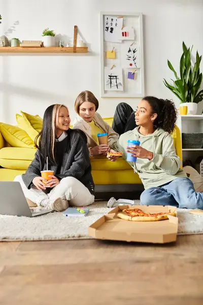 Amigos adolescentes multiculturales se reúnen en un vibrante sofá amarillo, compartiendo risas y lazos en un ambiente acogedor. - foto de stock