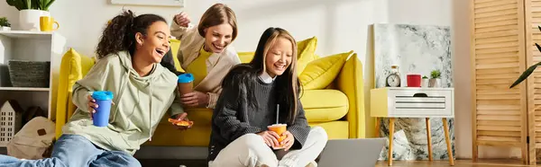 Разнообразная группа девочек-подростков счастливо отдыхают на желтом диване, источая дружбу и радость.. — стоковое фото
