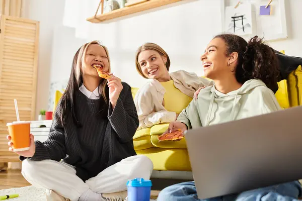 Drei Teenager unterschiedlicher Rassen sitzen auf dem Boden, genießen Pizzascheiben und trinken zusammen Orangensaft. — Stockfoto