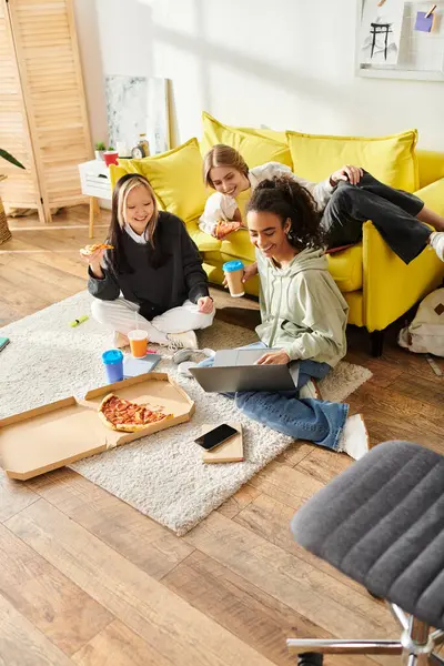 A diverse group of teenage girls of different ethnicities are seated on the floor in a warm living room, chatting and laughing. — Stock Photo