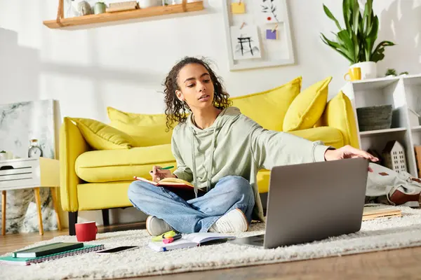 Una ragazza adolescente che studia a casa, profondamente assorta nell'e-learning sul suo computer portatile mentre è seduta sul pavimento. — Foto stock