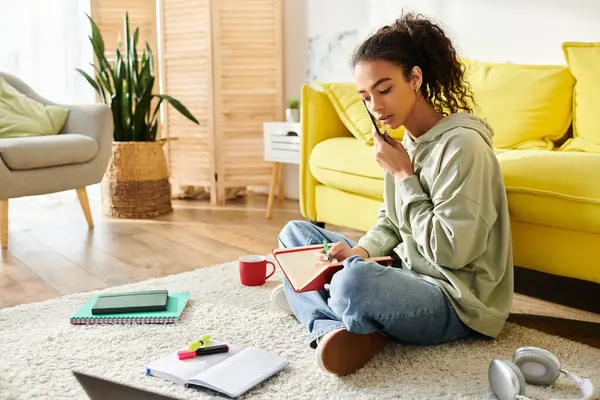 Une adolescente assise sur le sol, utilisant un téléphone portable pour l'apprentissage en ligne, pleinement engagée dans des sessions d'étude virtuelles. — Photo de stock