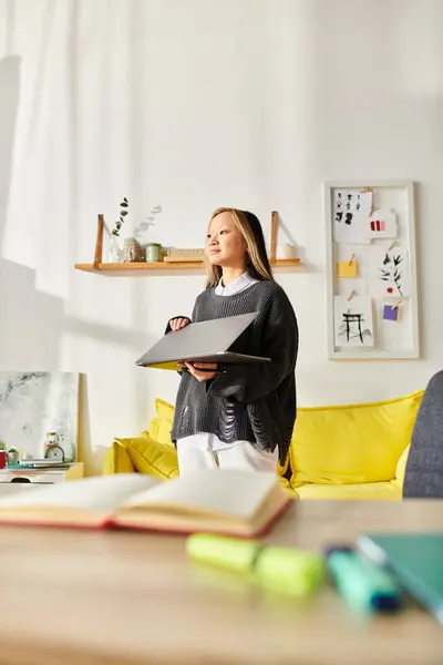 Uma jovem mulher asiática fica em uma sala de estar acolhedora, profundamente pensada enquanto segura um pedaço de papel para seus estudos de e-learning. — Fotografia de Stock