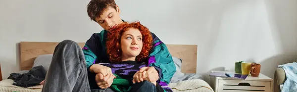 Appealing loving boyfriend and girlfriend in cozy vibrant clothing lying in bed and hugging warmly — Stock Photo