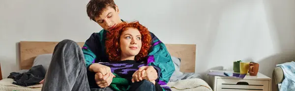 Ansprechende liebevolle Freund und Freundin in kuscheliger lebendiger Kleidung im Bett liegend und warm umarmt — Stockfoto