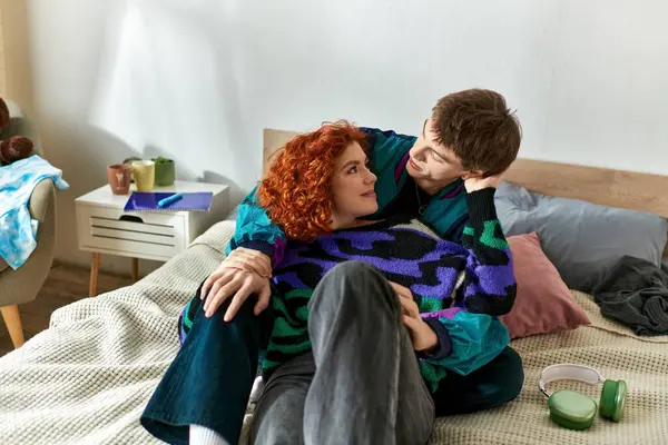 Stilvolles, fröhliches Paar in lässiger, gemütlicher Kleidung, das Zeit zu Hause verbringt und sich liebevoll im Bett umarmt — Stockfoto
