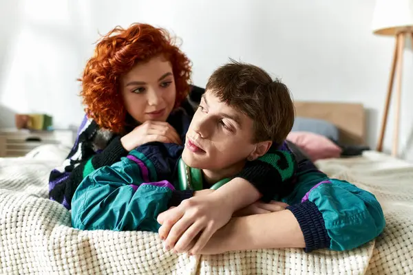 Beautiful cheerful woman lying in bed with her handsome young boyfriend with headphones at home — Stock Photo