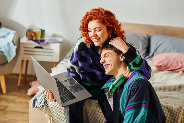 Red haired jolly woman spending quality time with her joyous boyfriend while at laptop at home — Stock Photo