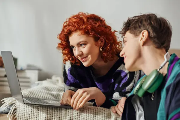 Appealing jolly man and his girlfriend having great time together and surfing in Internet on laptop — Stock Photo