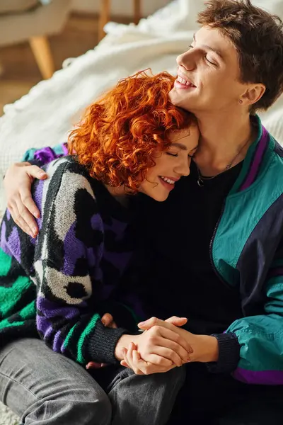 Good looking cheerful couple in fashionable outfits having good time and hugging warmly at home — Stock Photo