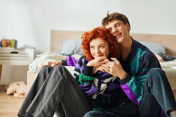 Alluring cheerful girlfriend and boyfriend in stylish outfits hugging each other while at home — Stock Photo