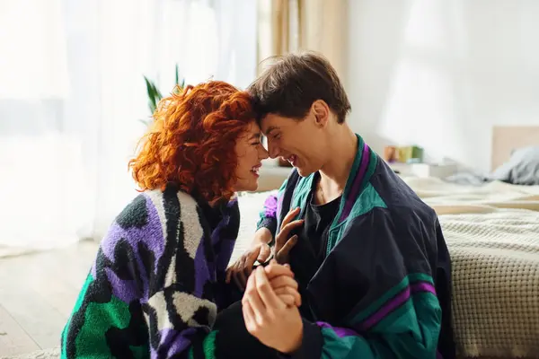 Atraente casal amoroso em trajes de moda olhando um para o outro, enquanto se divertindo em casa — Fotografia de Stock