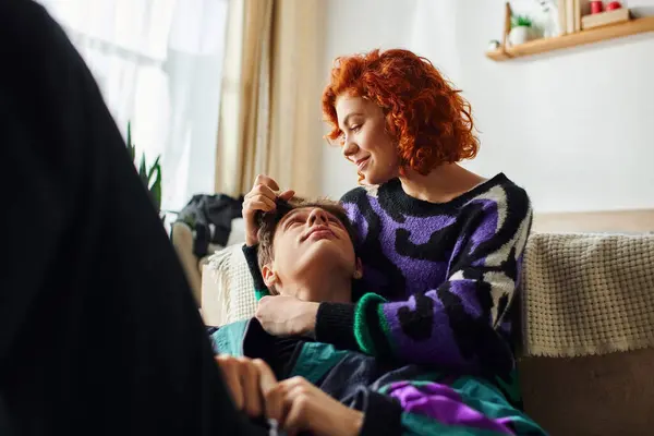 Cheerful red haired woman in casual attire hugging warmly her joyous boyfriend while at home — Stock Photo