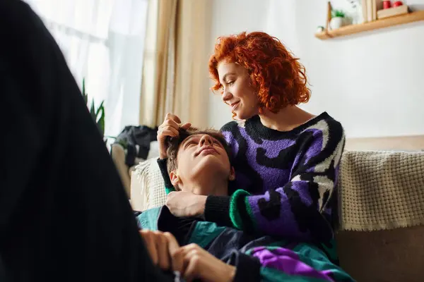 Mulher ruiva alegre em traje casual abraçando calorosamente seu namorado alegre enquanto em casa — Fotografia de Stock