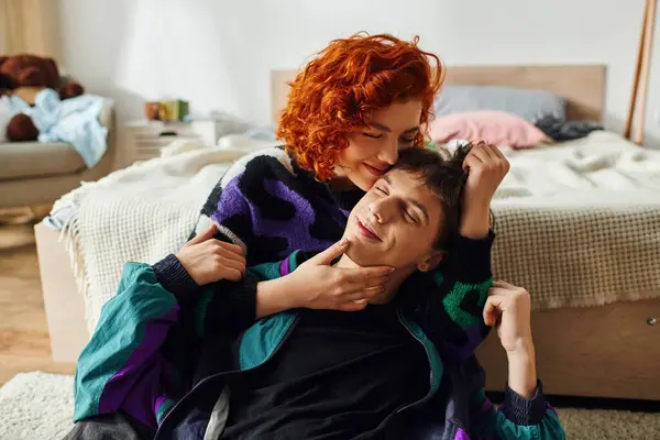 Belle femme joyeuse en tenue confortable étreignant son beau copain joyeux pendant qu'il est à la maison — Photo de stock