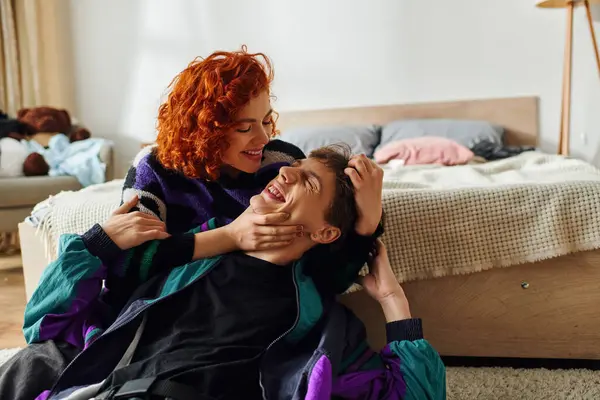 Cheerful attractive woman in cozy attire hugging passionately her handsome boyfriend at home — Stock Photo