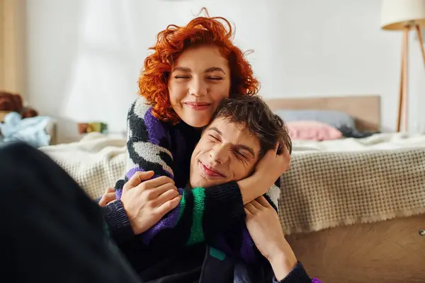 Стильная веселая женщина с рыжими волосами проводит время со своим парнем и обнимает его с любовью — стоковое фото