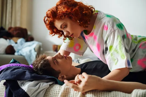 Heureux couple séduisant dans des vêtements confortables se préparant à embrasser séduisante tout en étant couché sur le lit ensemble — Photo de stock