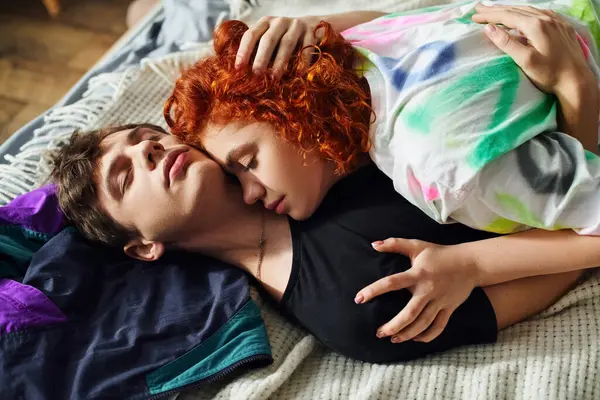 Alluring beautiful young couple in vibrant homewear hugging lovingly each other on bed at home — Stock Photo