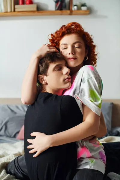 Alluring young fancy couple in cozy homewear hugging each other lovingly while lying together on bed — Stock Photo