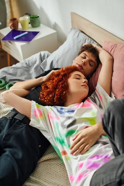 Attrayant amour jeune couple dans vibrant homewear détente ensemble dans leur lit alors qu'à la maison — Photo de stock