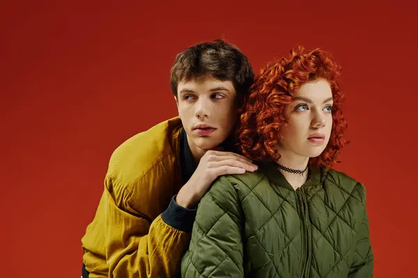 Loving good looking boyfriend and girlfriend posing alluringly together on red vibrant background — Stock Photo