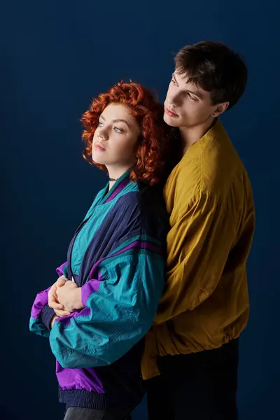 Attraente coppia amorevole in abbigliamento casual alla moda abbracciando allettante su sfondo blu scuro — Foto stock