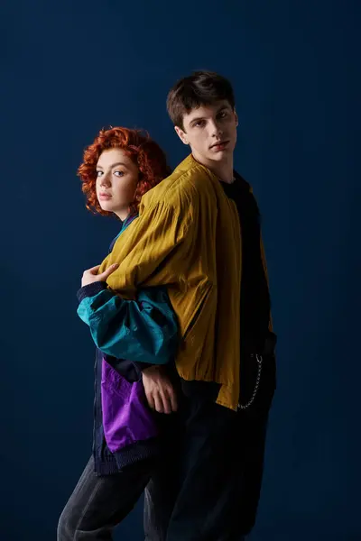 Good looking stylish couple in fashionable attire posing back to back and looking at camera — Stock Photo