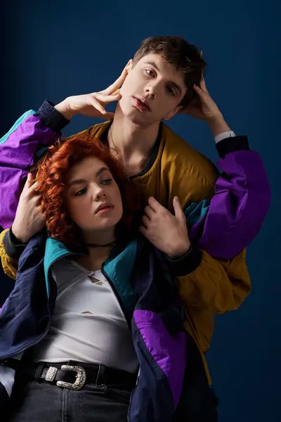 Good looking man in vibrant attire hugging his beautiful stylish girlfriend and looking at camera — Stock Photo