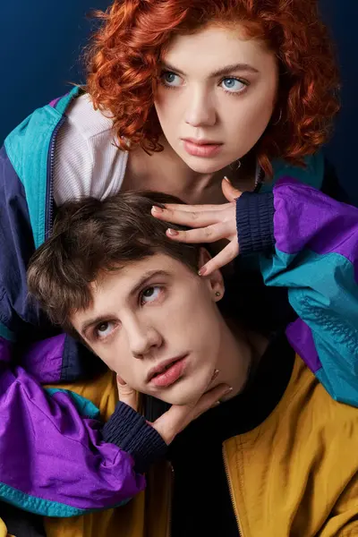 Elegante pareja de moda en atuendo casual posando juntos en el fondo azul y mirando a la cámara - foto de stock