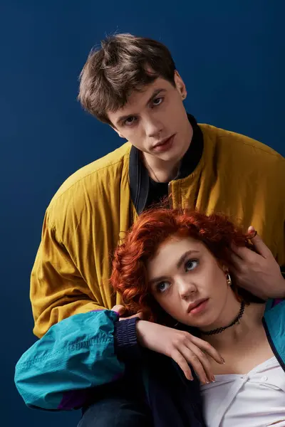 Young appealing man in stylish outfit hugging his red haired girlfriend and looking at camera — Stock Photo