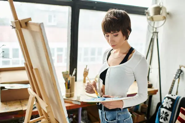 Woman paints at easel in garden. — Stock Photo
