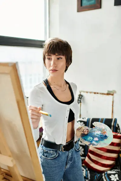A woman gracefully wields a brush and paints a masterpiece. — Stock Photo