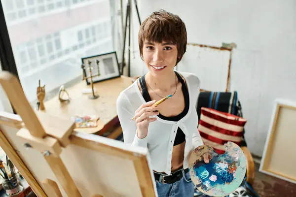 A woman holding a pencil, painting a picture. — Stock Photo