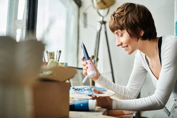 A woman painting a picture on a table. — Stock Photo