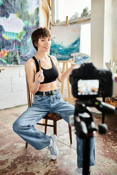 A woman sits gracefully in a chair, facing a camera. — Stock Photo