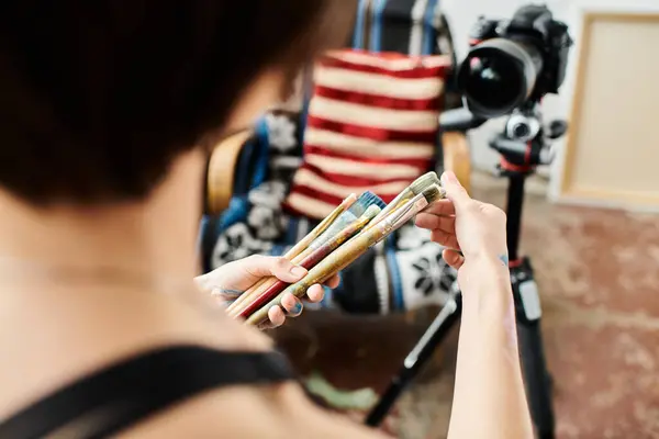 Una mujer con cepillos en la mano, lista para crear. - foto de stock