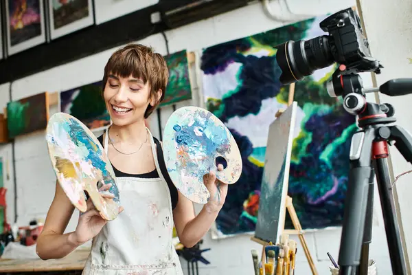 A woman showcasing two palettes in front of a camera. — Stock Photo