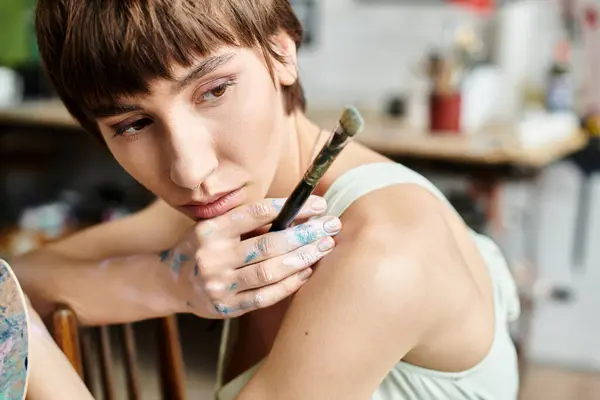 Appealing woman sitting with a paintbrush. — Stock Photo